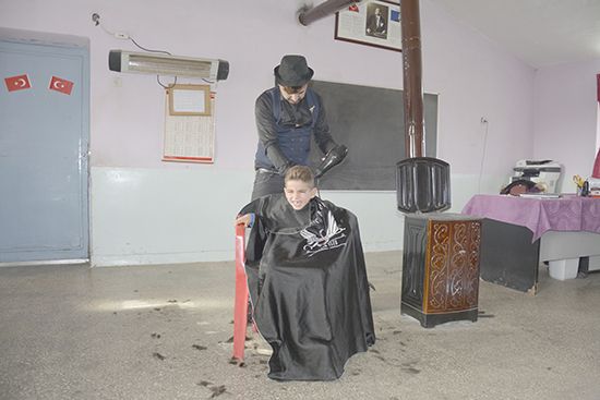 Köy okullarını gezip öğrencileri tıraş ediyor